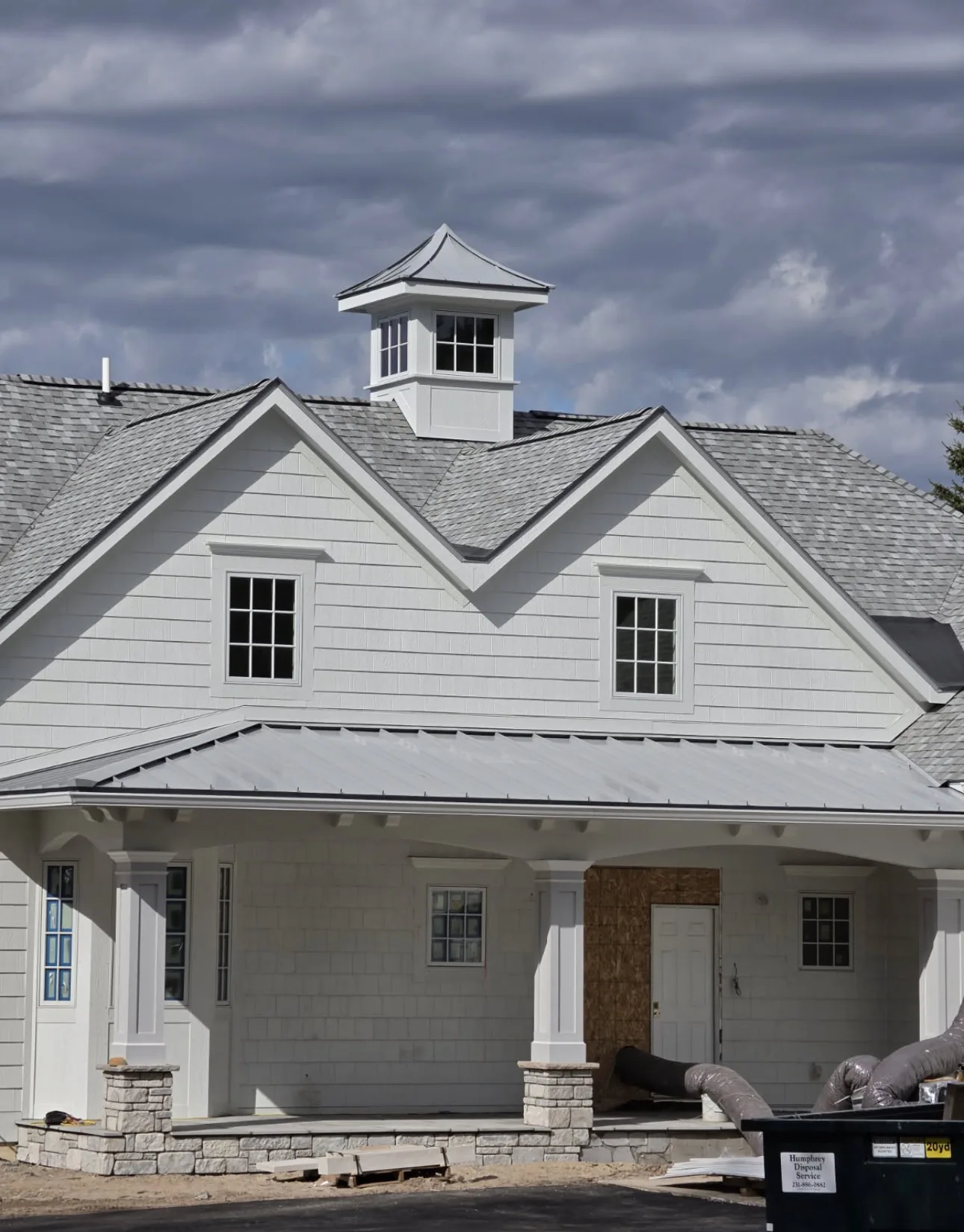 A Northern Michigan home under construction with a mix of metal and asphalt shingle roofing.