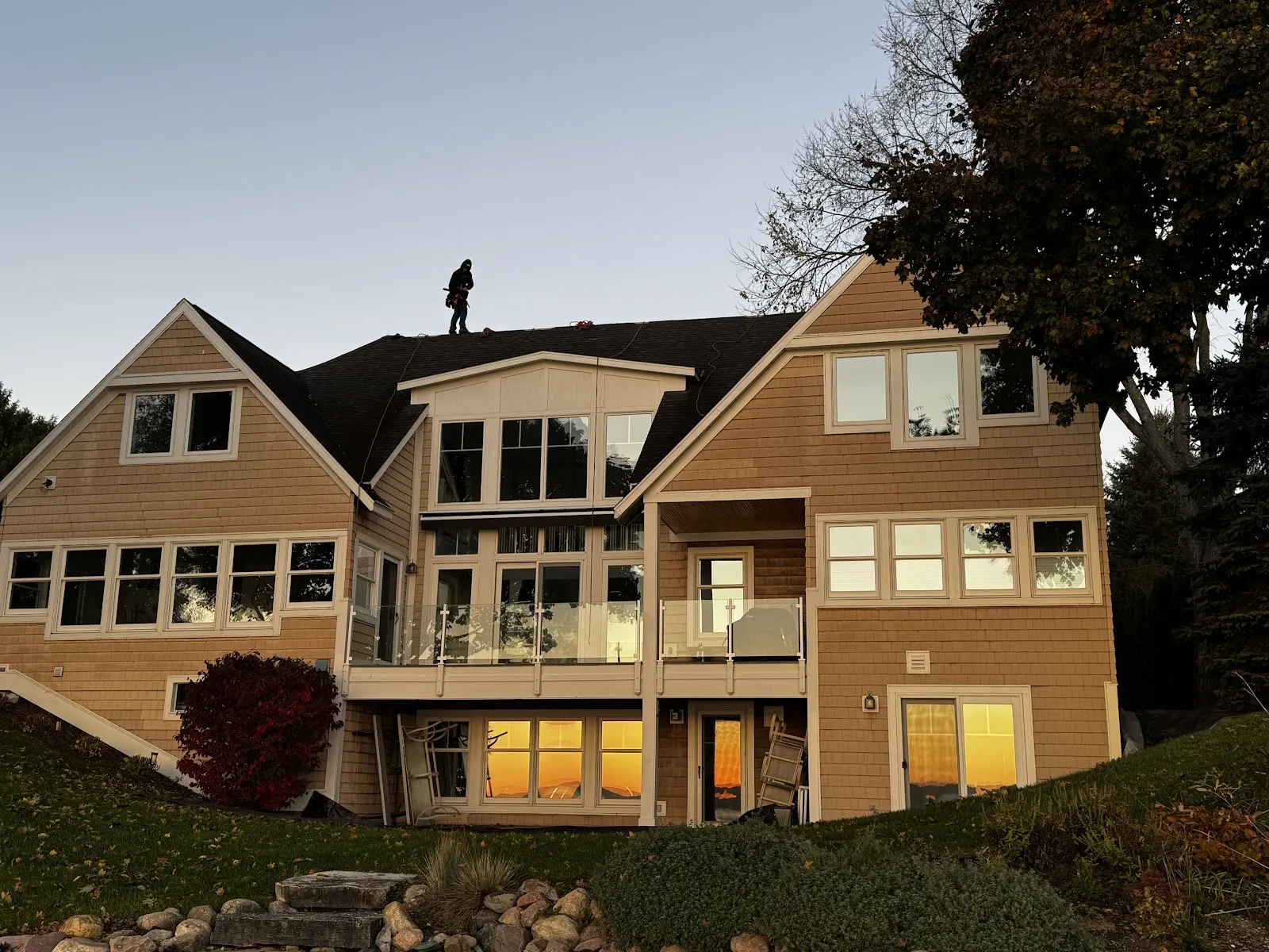 A modern Northern Michigan home with a quality roof at sunset.
