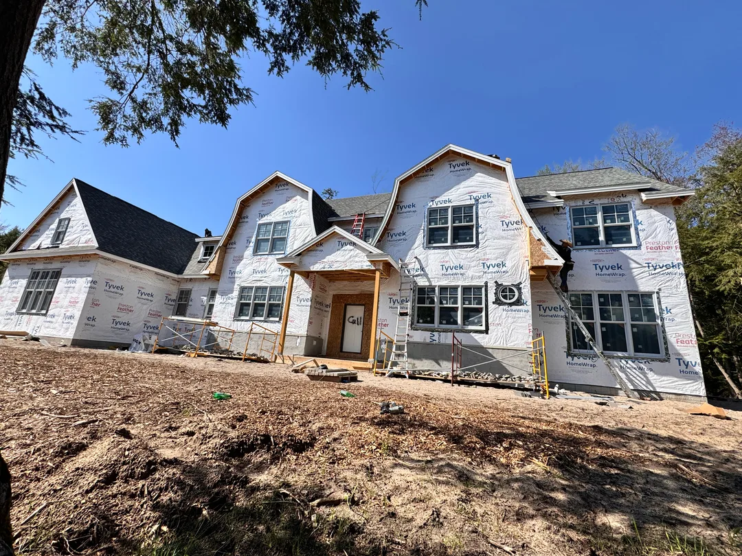 A new home under construction in Traverse City with roofing work underway.