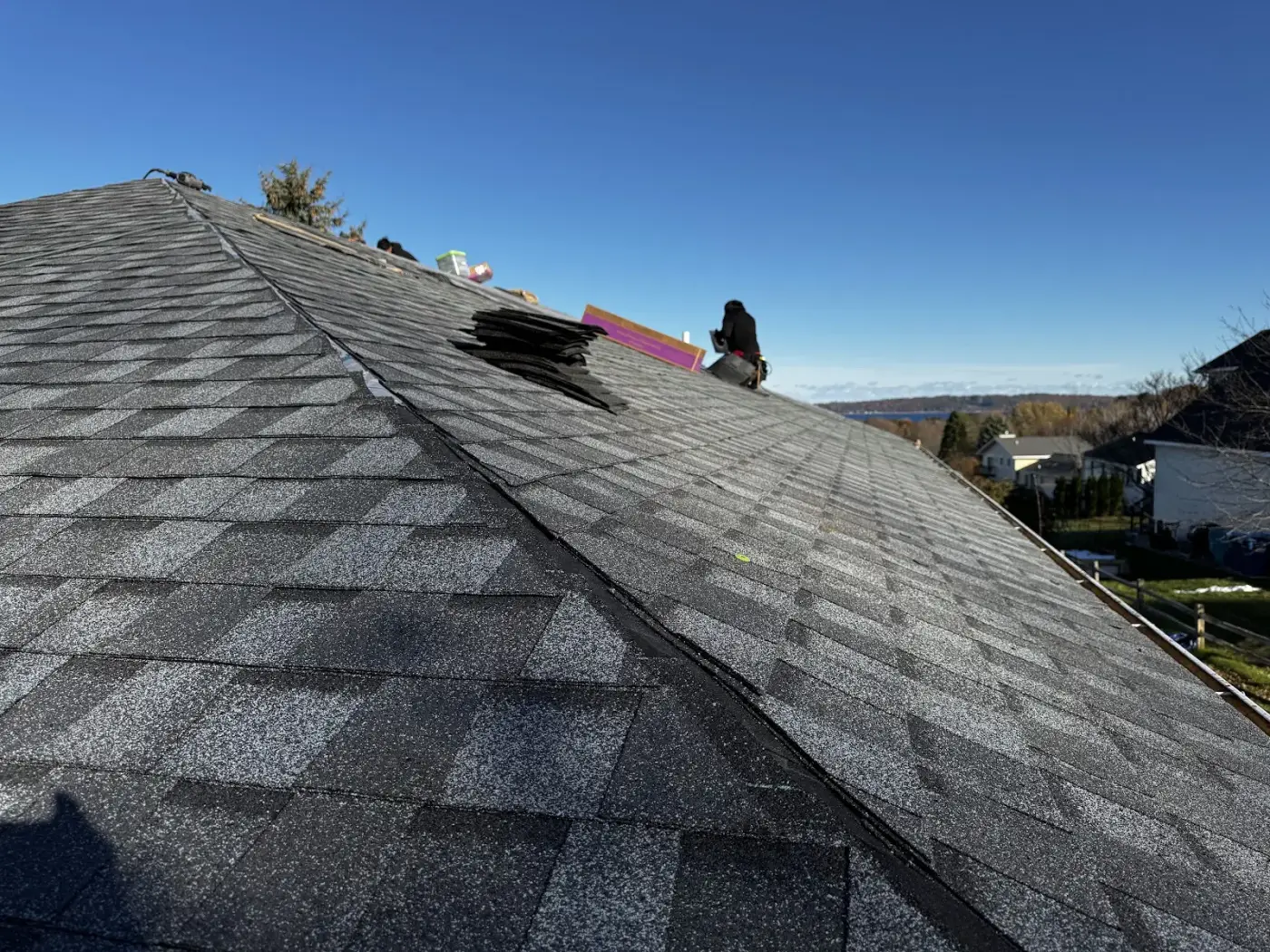 A Falcon Roofing installer laying new shingles