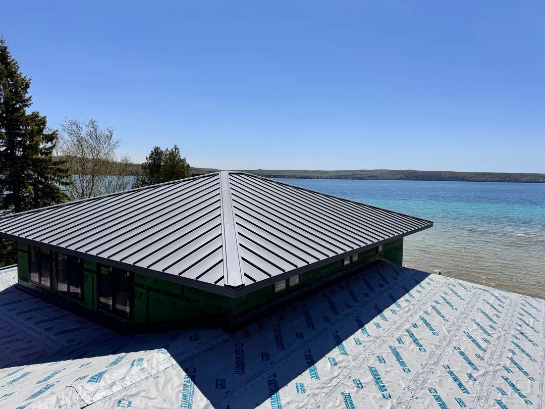 A standing seam metal roof on a building overlooking a Northern Michigan bay.
