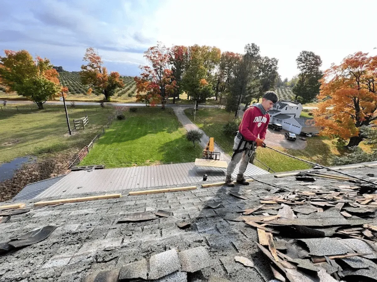 Roofing crew removing damaged shingles during a repair job